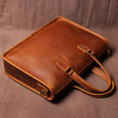 Men's Crazy Horse Leather Briefcase | Vintage Laptop Bag – Vintage Brown Top & Side Angle View Showing Zipper, Stitching, Top Handles, Antique Brass Hooks and Shoulder Strap Hook Detail on Brown Textured Background by Avenue