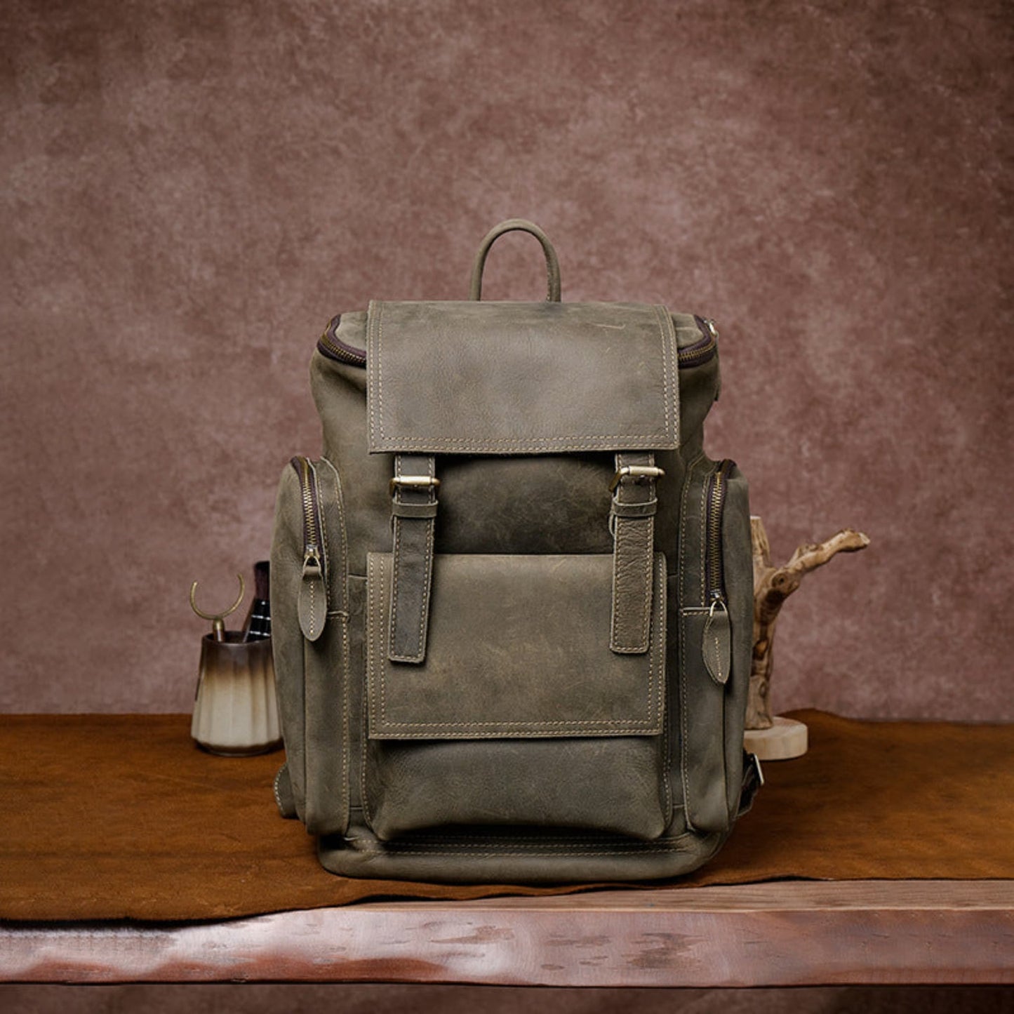 Retro crazy horse leather Men's laptop backpack large capacity in army green on wooden surface and brown background – front view | Avenue