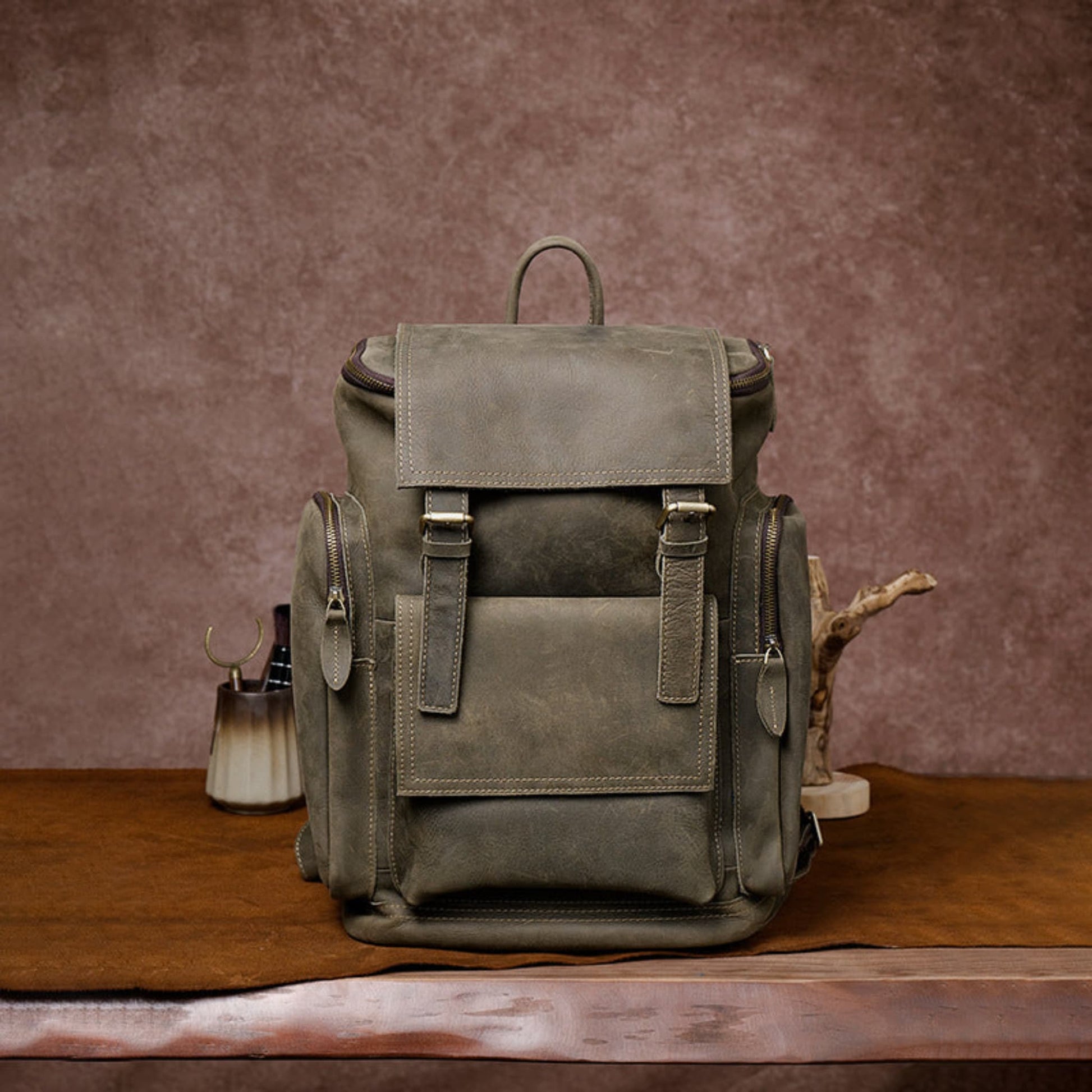 Retro crazy horse leather Men's laptop backpack large capacity in army green on wooden surface and brown background – front view | Avenue