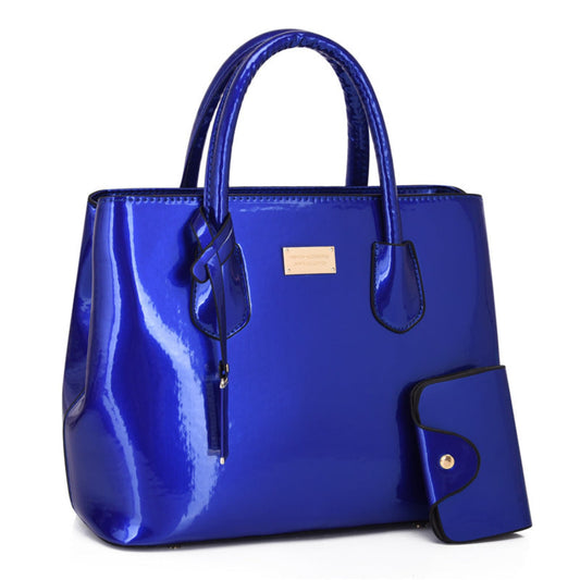 Women's glossy PU leather tote bag and pouch set in blue, gold hardware detail, white background | Avenue