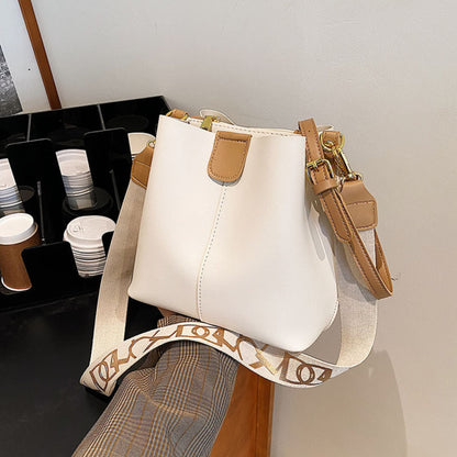 Avenue Wide Shoulder Strap Bucket Bag for Women in Beige - PU Leather Crossbody Bag Front View with Adjustable Patterned Shoulder Strap and Gold Hardware
