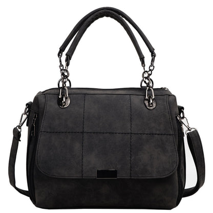 Women's black matte PU leather large capacity Boston shoulder tote bag with dual top handles, silver chain hardware, quilted stitch detail, front flap closure, and adjustable crossbody strap — Avenue