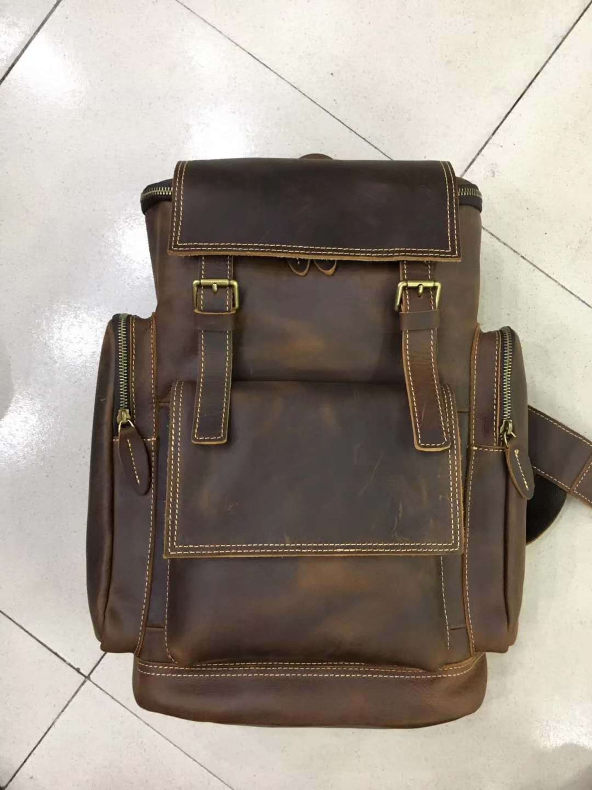 Retro crazy horse leather Men's laptop backpack large capacity in brown on tiled floor – front view | Avenue