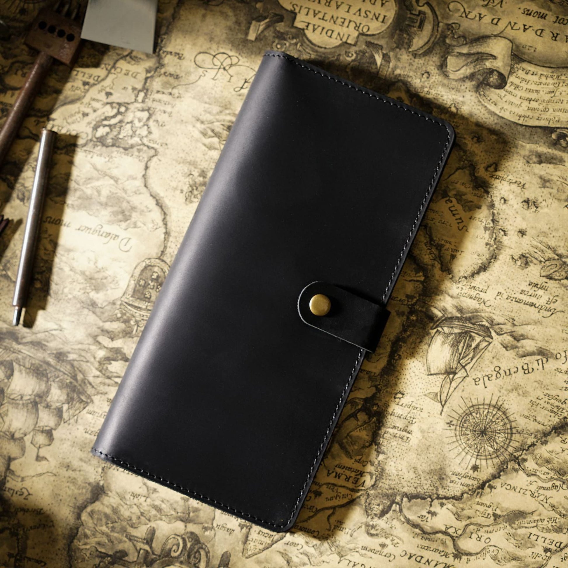 Avenue Retro Crazy Horse Leather Long Wallet in Black – Unisex Genuine Leather Wallet with Brass Snap Closure, styled on a vintage world map with leather crafting tools