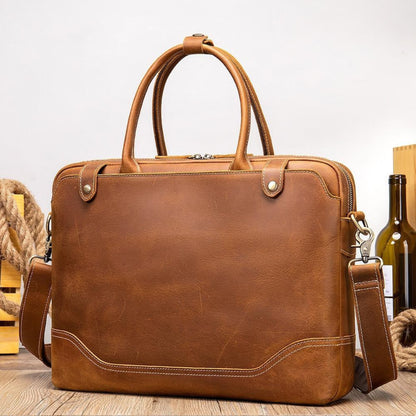 Avenue Crazy Horse Leather Men's Laptop Briefcase — coffee, front lifestyle view on wooden surface with rope and wine bottle, dual handles, brass zipper, shoulder strap, retro vintage style