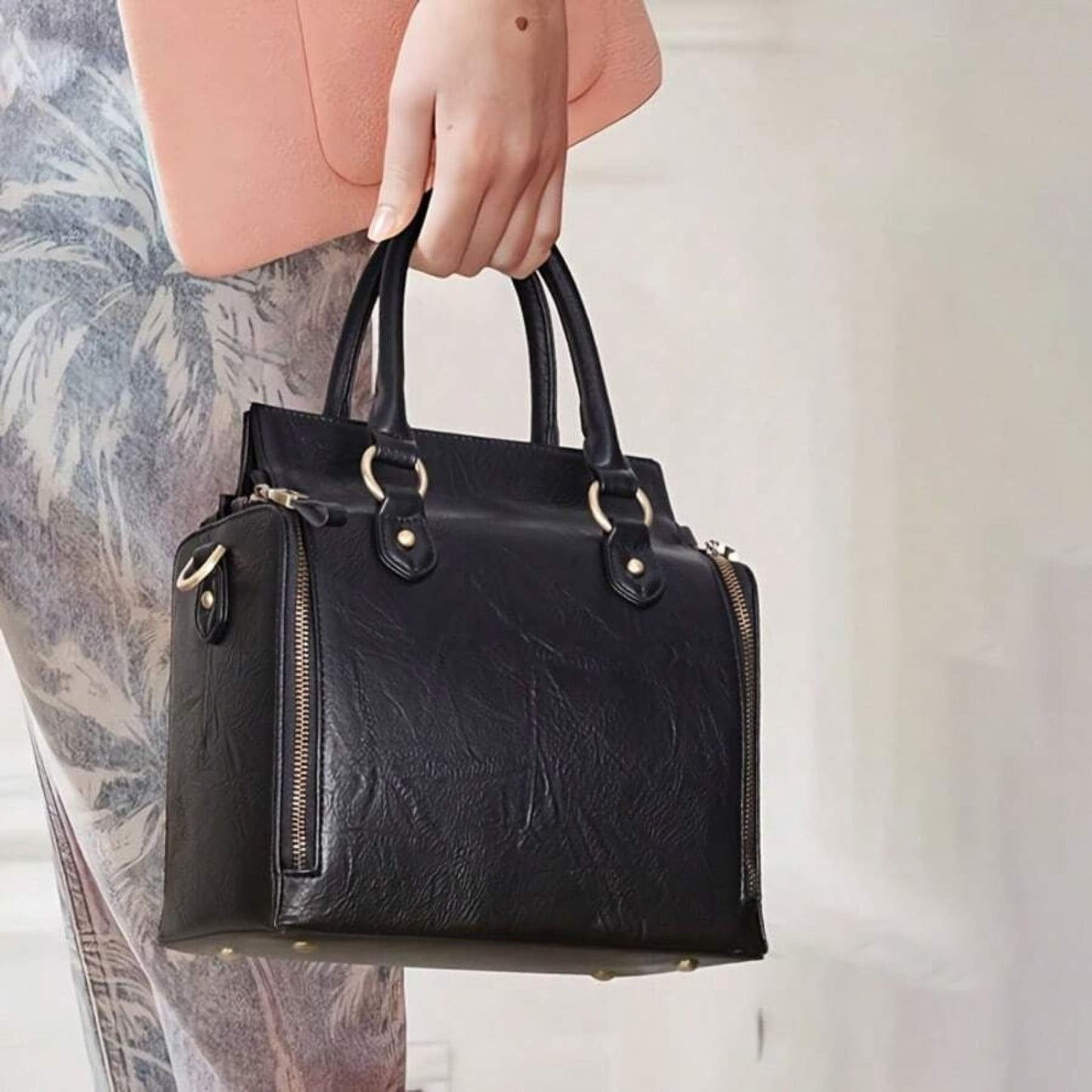 Model holding ladies glossy vintage tote bag, lifestyle view on light background | Avenue