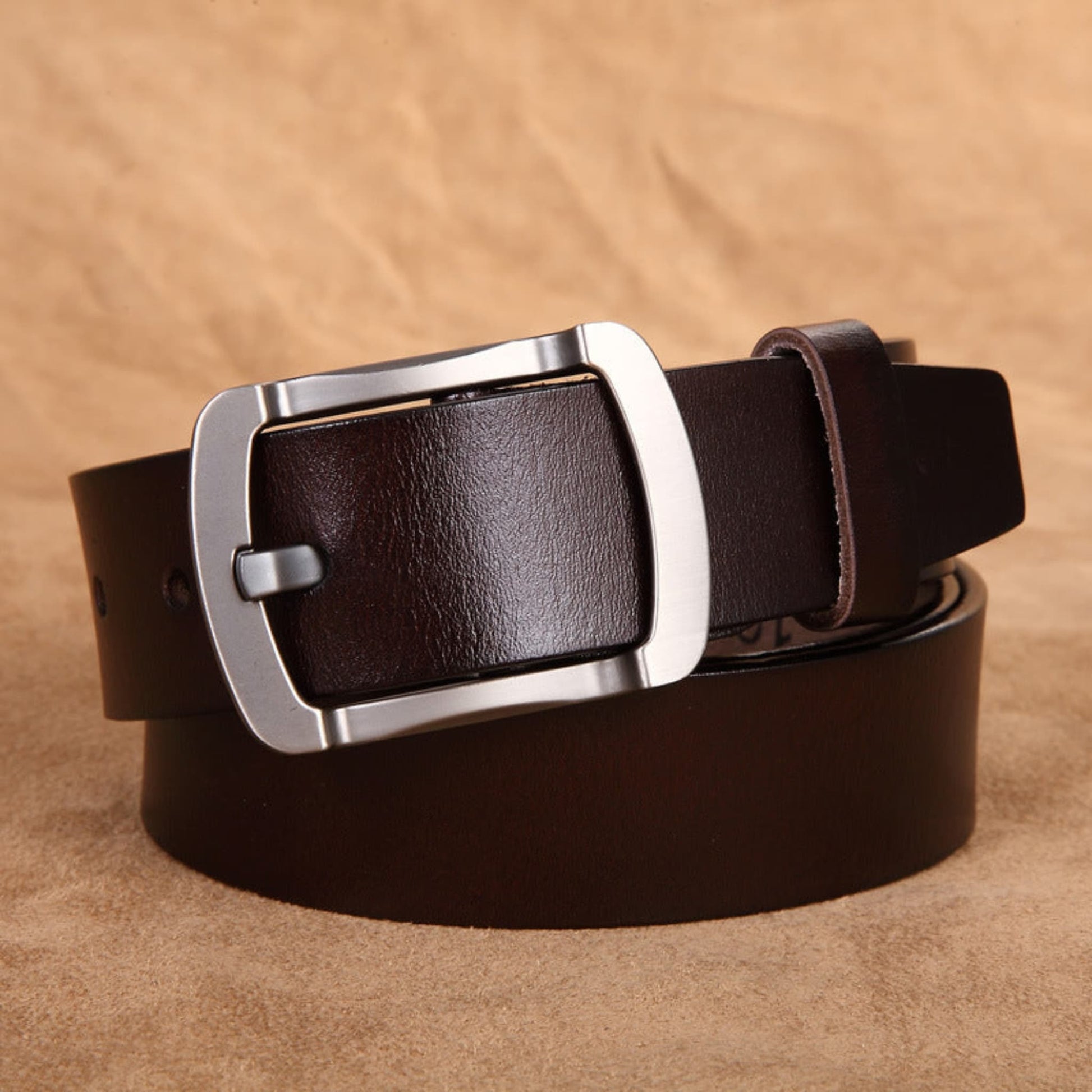Avenue Men's Genuine Cowhide Leather Retro Belt in Coffee with brushed gunmetal pin buckle, rolled view on tan leather background