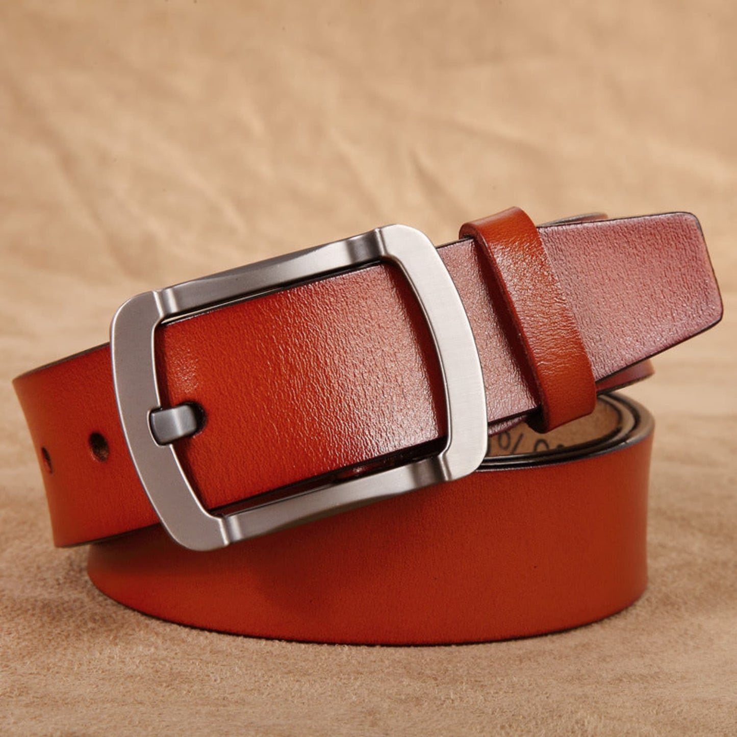 Avenue Men's Genuine Cowhide Leather Retro Belt in Camel with brushed gunmetal pin buckle, rolled view on tan leather background