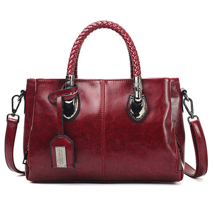 Women's vintage oil wax PU handbag in Dark Brown with braided handle on white background front view | Avenue