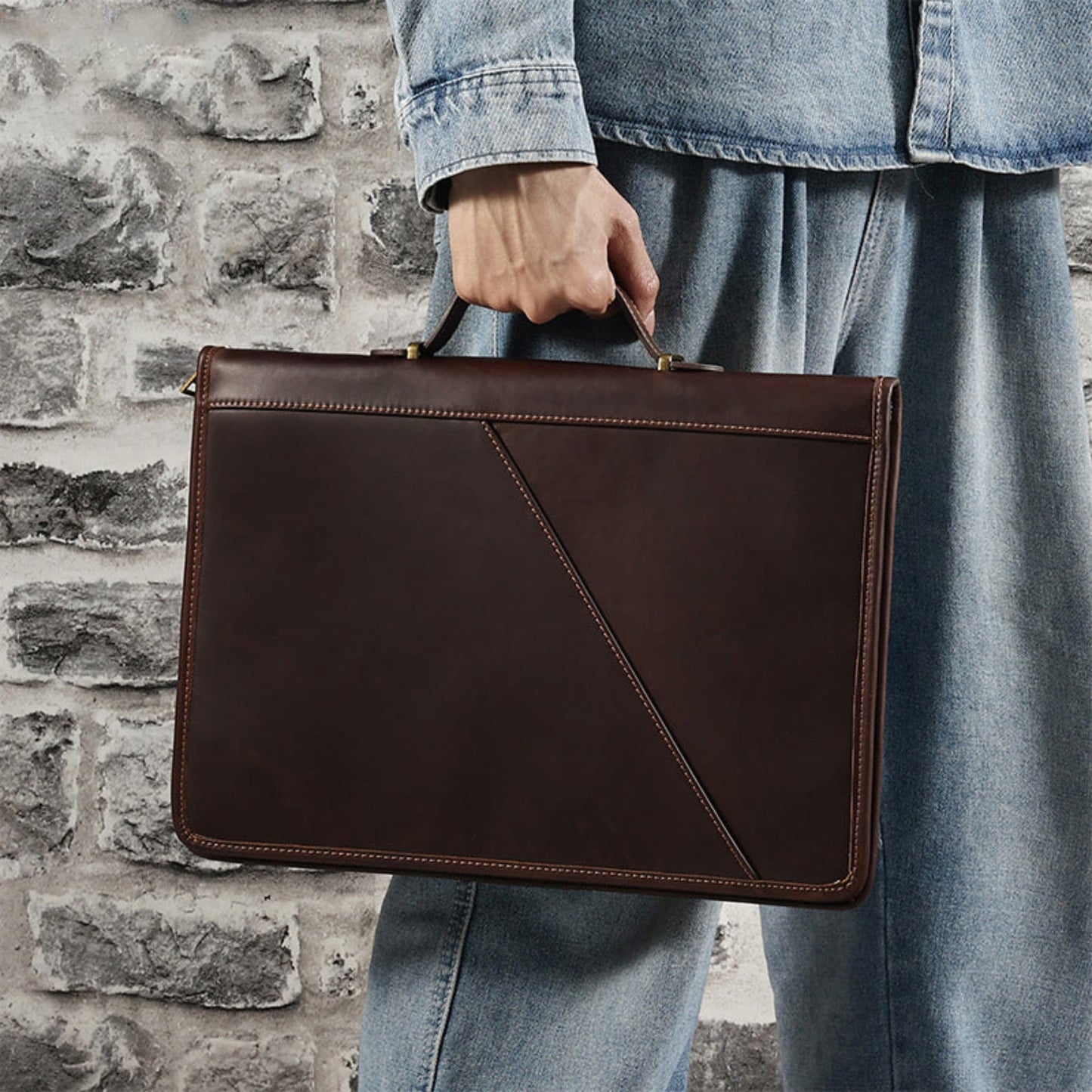 Avenue Crazy Horse Leather Laptop Bag – 14 Inch Vintage Briefcase Handbag in Coffee, held by hand against a stone wall background