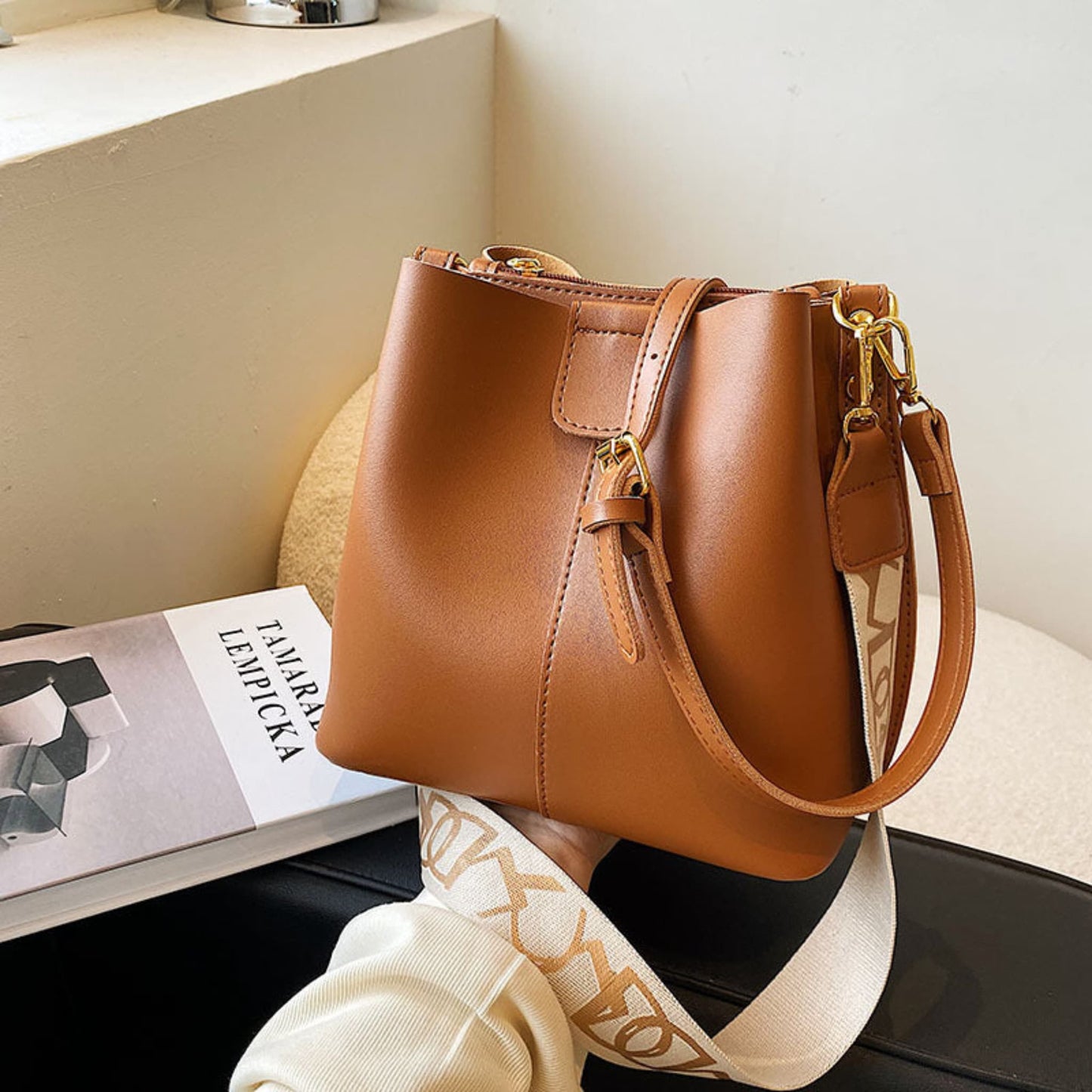 Avenue Wide Shoulder Strap Bucket Bag for Women in Brown - PU Leather Crossbody Bag Front View with Adjustable Patterned Shoulder Strap and Gold Hardware