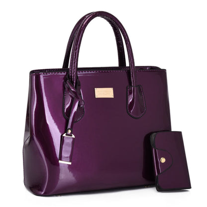 Women's glossy PU leather tote bag and pouch set in purple, gold hardware detail, white background | Avenue
