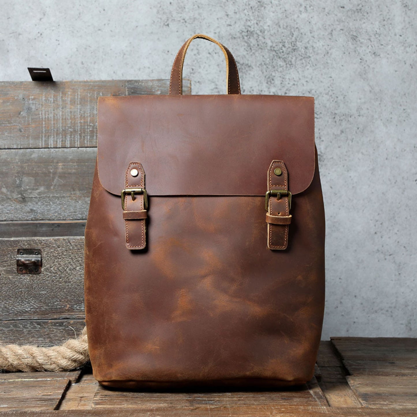 Avenue Retro First Layer Cowhide Leather Backpack – Brown Front View with Brass Buckle Closure on Rustic Wood Background
