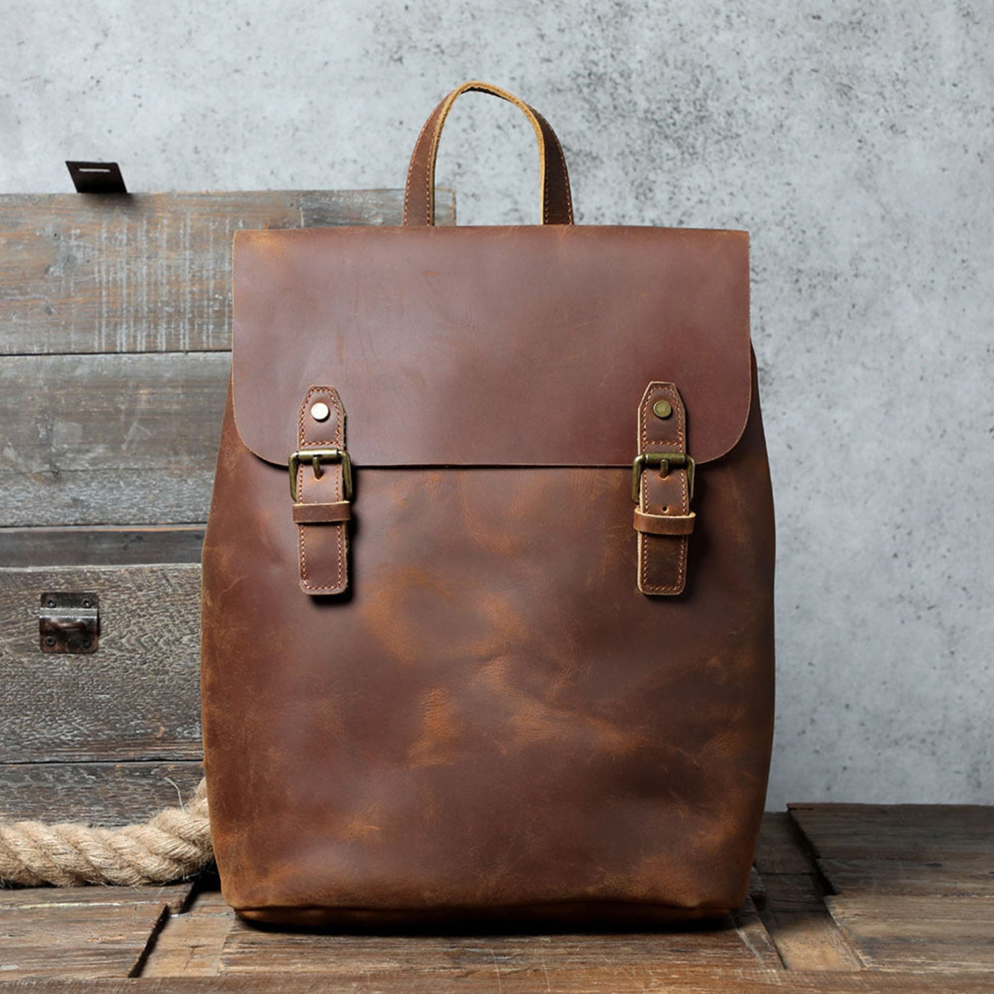 Avenue Retro First Layer Cowhide Leather Backpack – Brown Front View with Brass Buckle Closure on Rustic Wood Background
