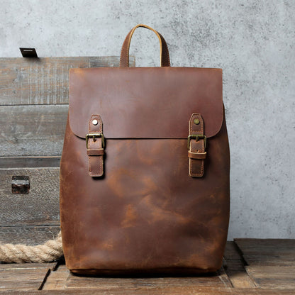Avenue Retro First Layer Cowhide Leather Backpack – Brown Front View with Brass Buckle Closure on Rustic Wood Background