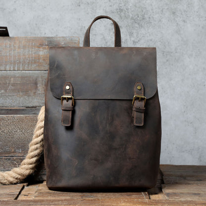Avenue Retro First Layer Cowhide Leather Backpack – Coffee Front View with Brass Buckle Closure on Rustic Wood Background