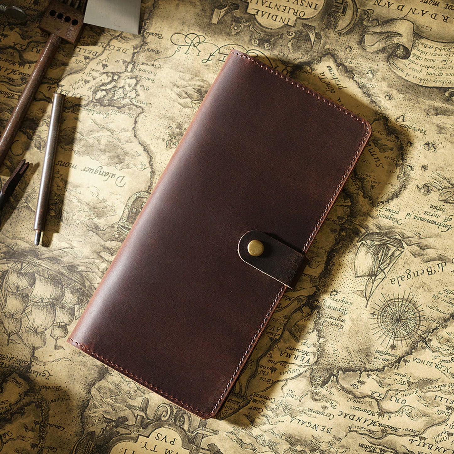 Avenue Retro Crazy Horse Leather Long Wallet in Coffee – Unisex Genuine Leather Wallet with Brass Snap Closure, styled on a vintage world map with leather crafting tools