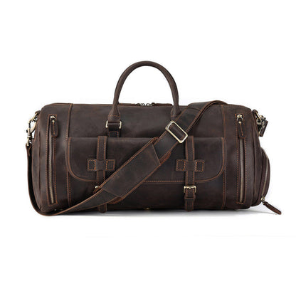 Front view of Avenue’s coffee Top-Grain Cowhide Leather Travel Duffle Bag with twin handles, adjustable shoulder strap, buckle-secured flap pocket, and side zipper pockets on a white background.