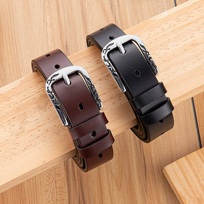 Women's Slim Black and Brown Leather Belts with Engraved Floral Silver D-Buckle Draped on Wooden Plank – Avenue
