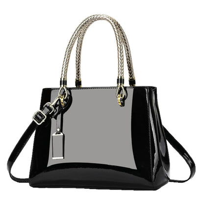 Black glossy patent leather shoulder bag with gold accents on a white background | Avenue