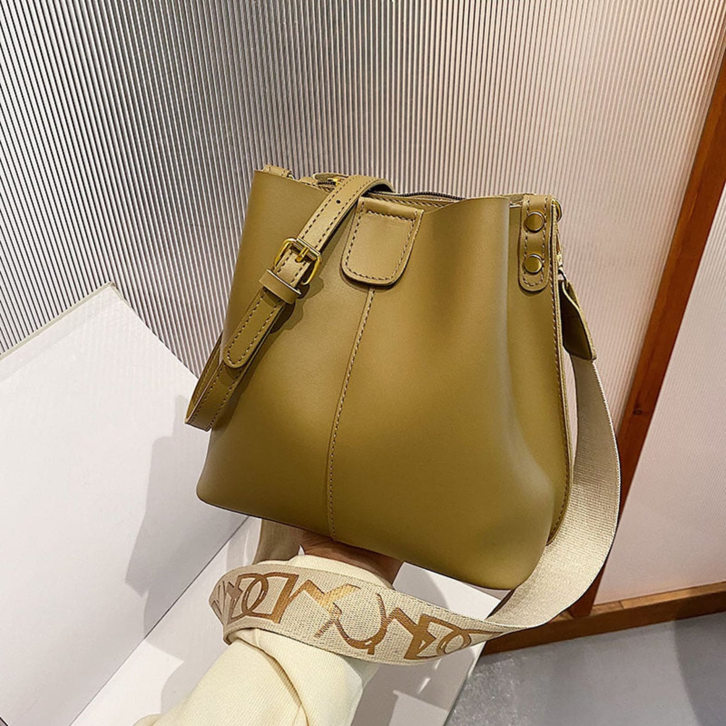 Avenue Wide Shoulder Strap Bucket Bag for Women in Tea Green - PU Leather Crossbody Bag Front View with Adjustable Patterned Shoulder Strap and Gold Hardware