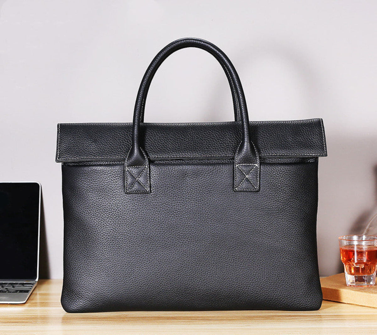 Avenue Vintage Crazy Horse Leather Briefcase – 15 Inch Laptop Bag for Men & Women, Black lychee cowhide, front view showing top handle, cover closure and structured body on wooden desk with laptop, lifestyle shot