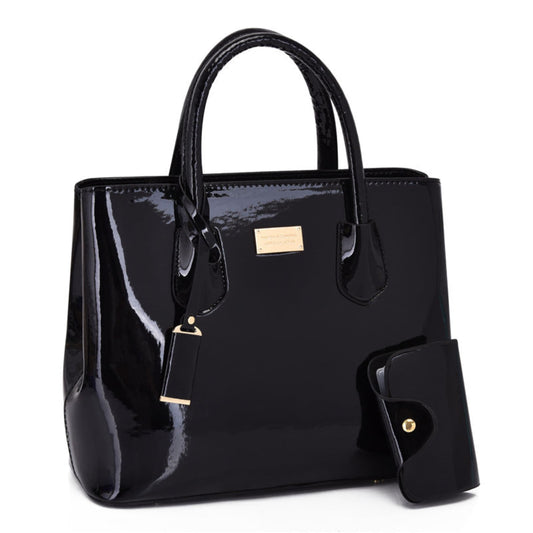 Women's glossy PU leather tote bag and pouch set in black, gold hardware detail, white background | Avenue